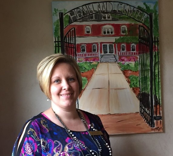 jen murray, Director of Personal Care, standing next to homeland center art
