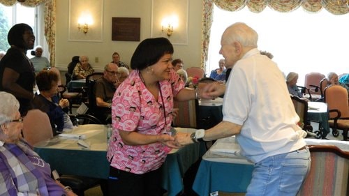 Resident Don Englander and staff member Aprile Greene share their joy during the performance