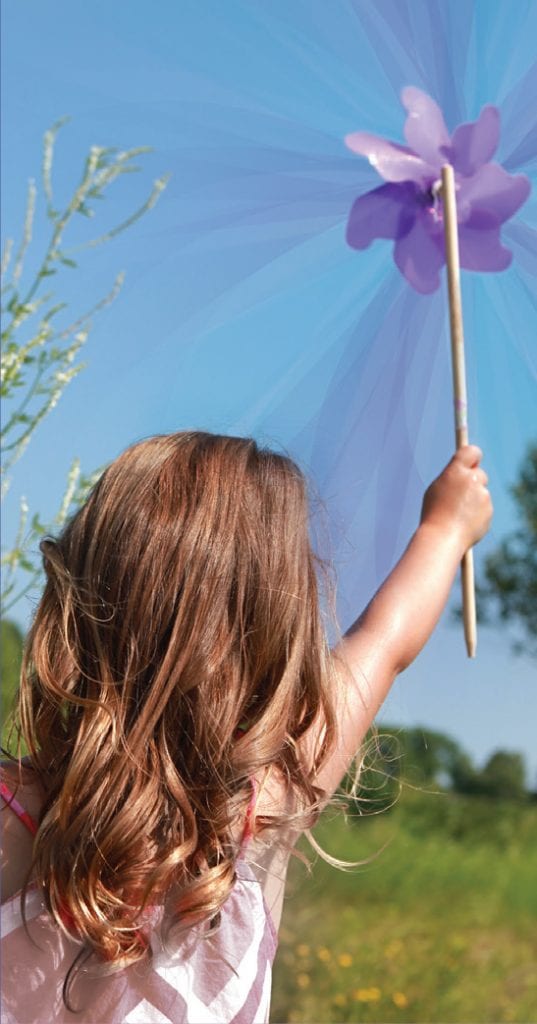 child holding up pinwheel to the wind