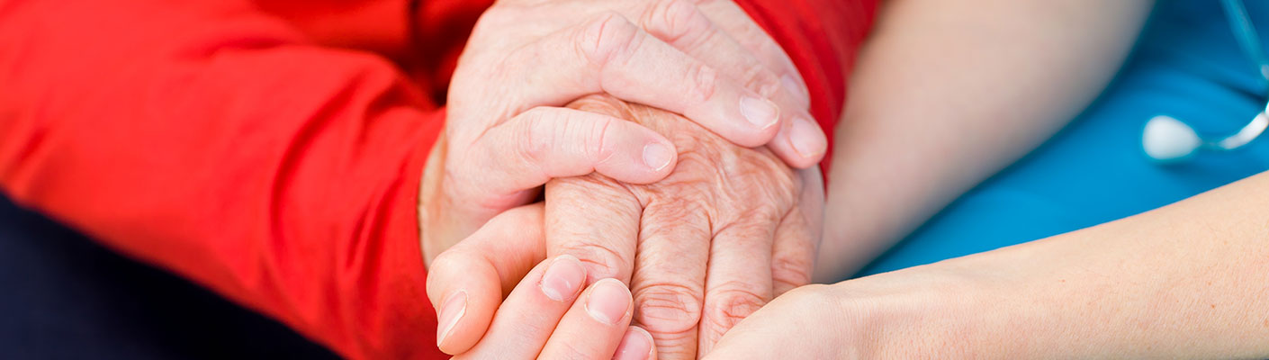 two pairs of folded hands - a nurse and patient