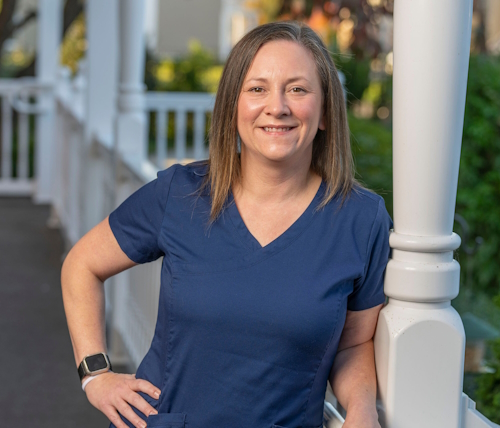 Aimee Schmoltze, registered hospice nurse, smiling on a porch