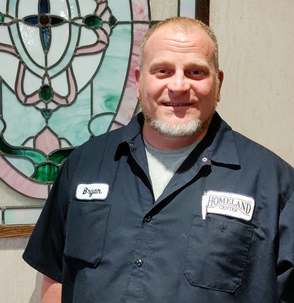 Bryan Richards, Homeland maintenance, smiling next to stained glass