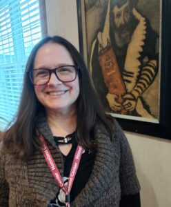 Manager of Strategy and IT Jennifer Ross next to art