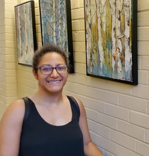 artist nicole simmons next to her artwork