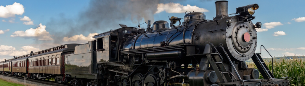 banner of a train passing a corn field on a sunny day