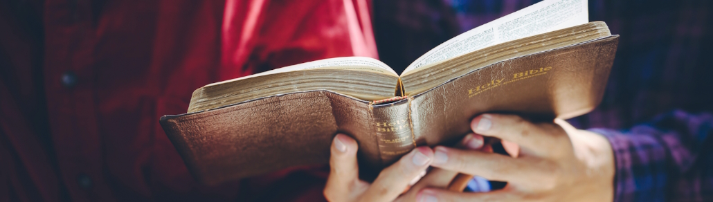 banner close up of hands holding a holy bible