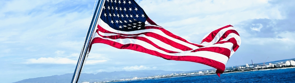 banner of an american flag flying over a shore
