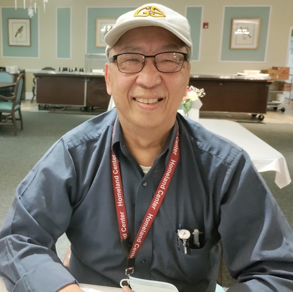 Homeland Chef Manager George Shum smiling in a dining room