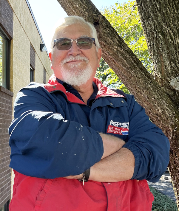 Hospice Volunteer Tom Barry looking proud next to a tree