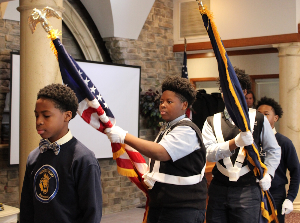 a group of students transporting flags during a veterans ceremony